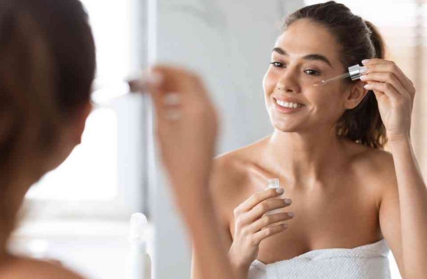 a beautiful woman putting some skin secrets drops on her face